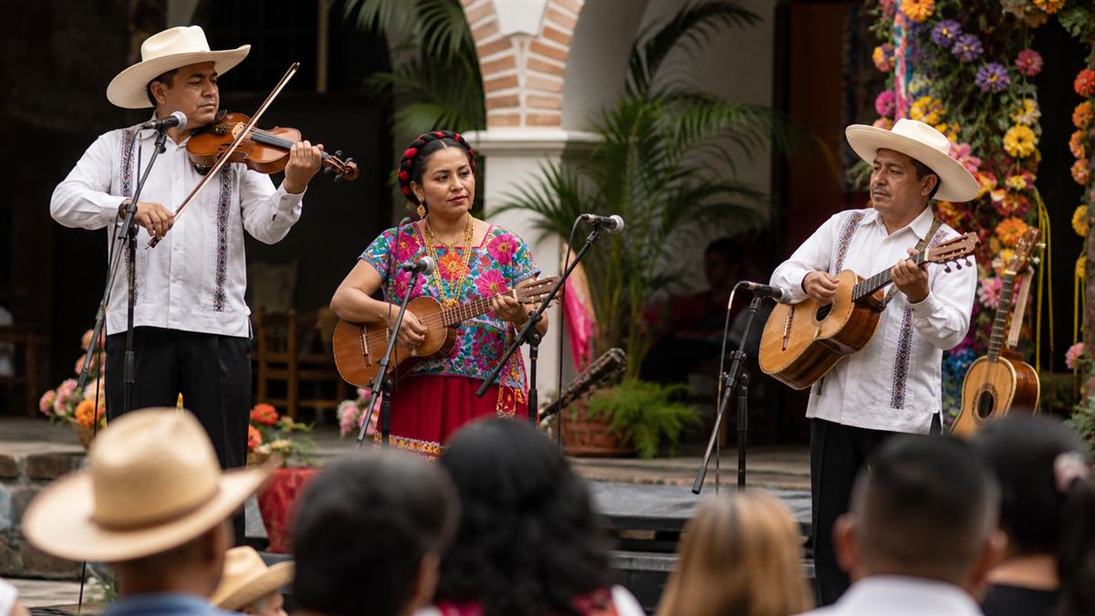 Músicos interpretan instrumentos tradicionales mexicanos en un escenario cultural